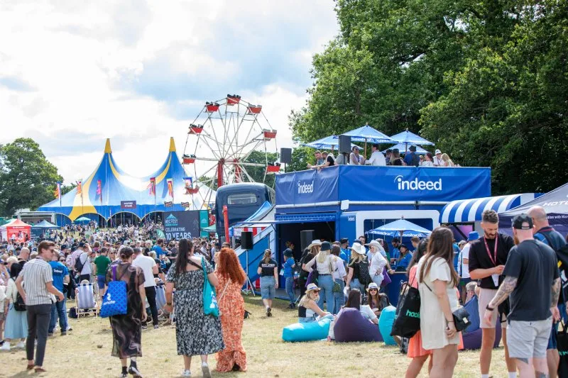 A large crowd at an outdoor event with attractions and festivities