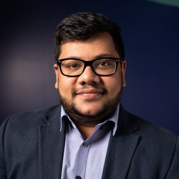 Headshot of Rohan Sylvester - Rohan wears glasses and a suit. He is looking at the camera.