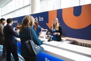 Une femme s'enregistre sur une tablette à Indeed FutureWorks et discute avec une employée d'Indeed