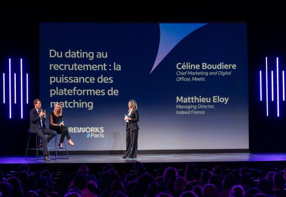 Three speakers presenting on a stage at an event