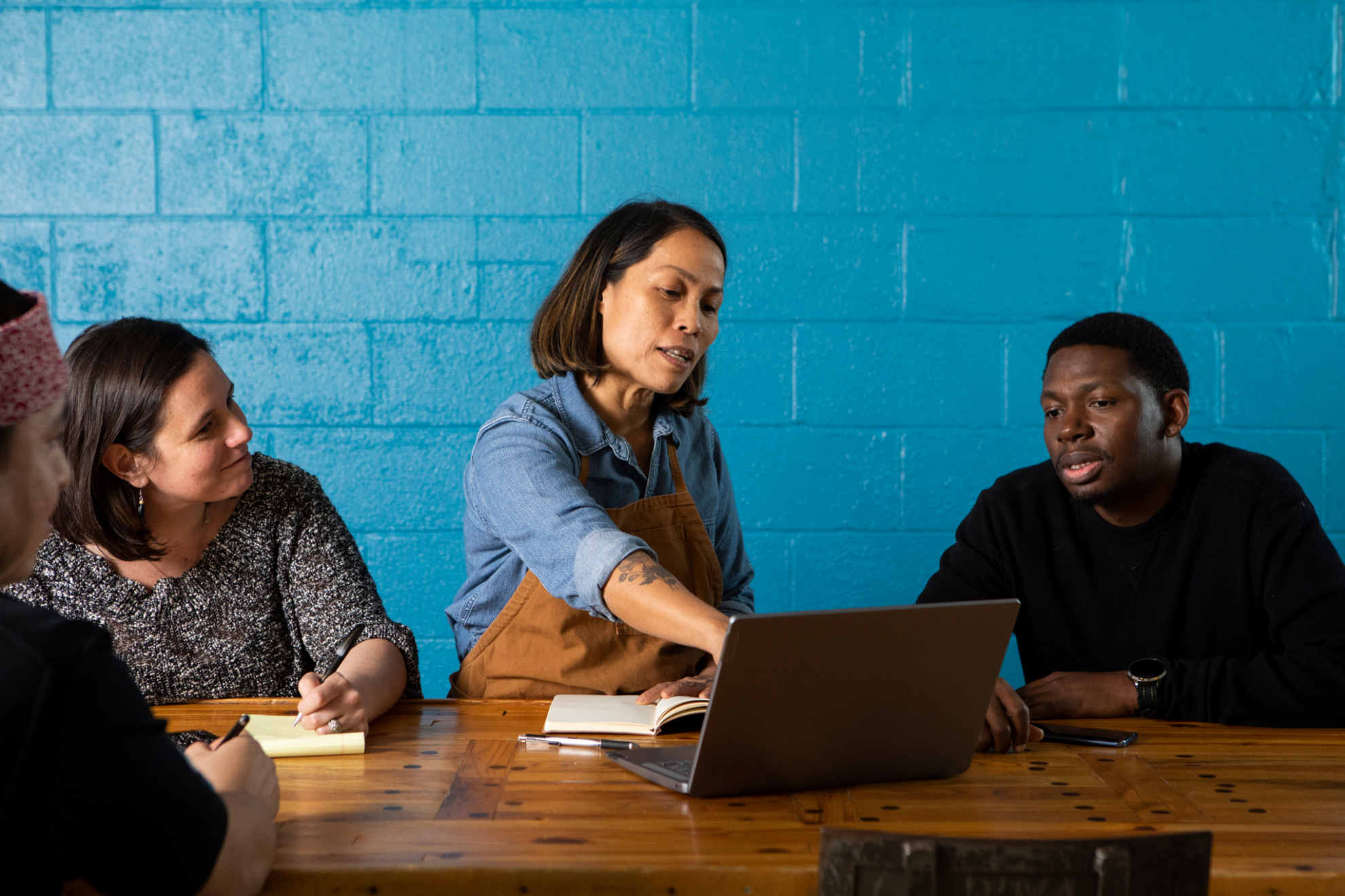 Group of people discussing what they can see on their computer.