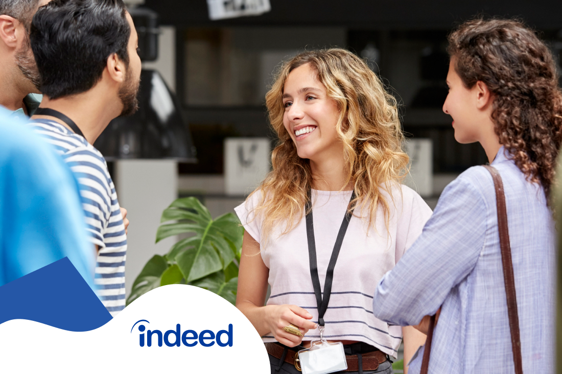 A group of 2 men and 2 women chatting at a conference break.