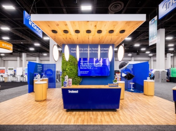 A brightly-lit booth with Indeed signage in an open space