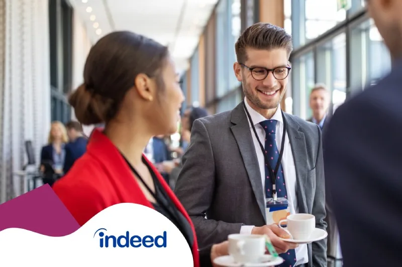 Three people smiling and conversing at an event