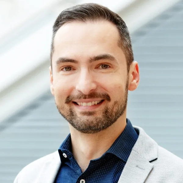 Headshot photo of Pawel Adrjan looking at the camera