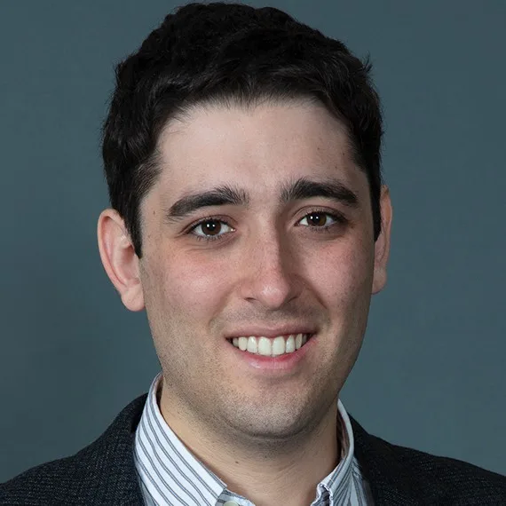 Headshot photo of Ezra Karger looking at the camera